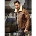 Man wearing a brown leather jacket with a white fur collar in an industrial setting