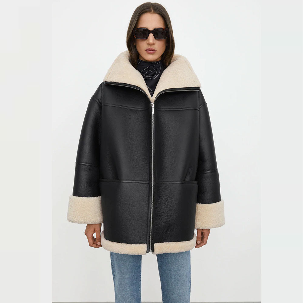 Woman wearing a black leather jacket with white fur trim on a white background